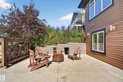 Concrete patio featuring a retaining wall, integrated outdoor lighting, and horizontal siding - 
