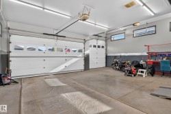 Attached three-car garage featuring two overhead doors with windows and an additional single overhead door - 
