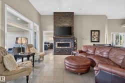 Stone-clad fireplace with a wood-mantel, integrated fireplace unit, and recessed lighting - 