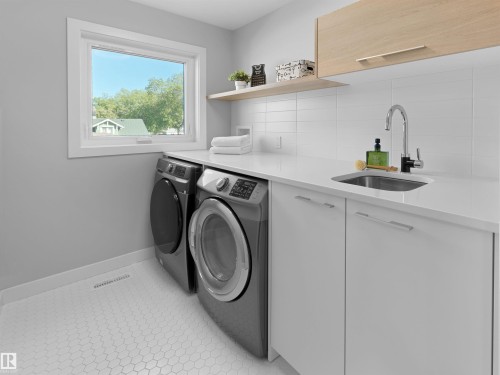 White hexagon tile flooring, a built-in utility sink with a chrome faucet, white flat-panel cabinetry, a light wood-finish floating shelf, and a light wood-finish upper cabinet - 9118 89 Street Nw, Edmonton, AB 