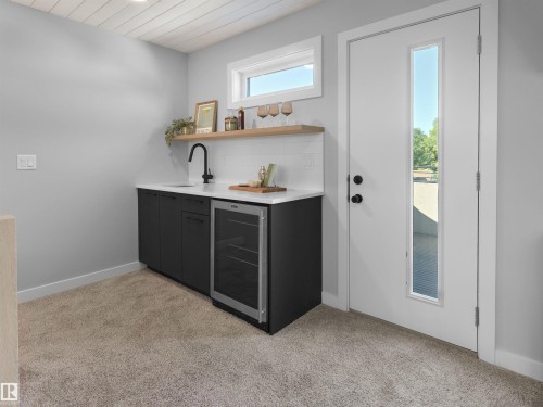 Built-in wet bar with dark cabinetry, white countertop, and stainless steel beverage refrigerator - 9118 89 Street Nw, Edmonton, AB 