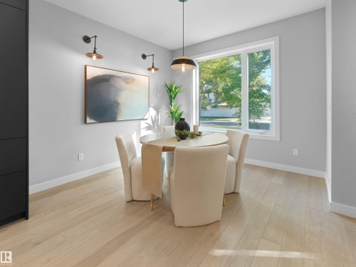 Recessed lighting with a contemporary pendant fixture, light wood-finish flooring, and a large window providing natural illumination - 9118 89 Street Nw, Edmonton, AB 