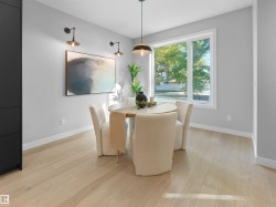 Recessed lighting with a contemporary pendant fixture, light wood-finish flooring, and a large window providing natural illumination - 