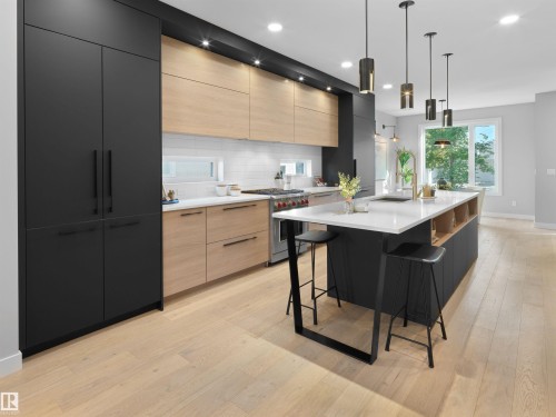 Sleek kitchen featuring light wood-finish flooring, a central island with white countertop, integrated black cabinetry, under-cabinet lighting, and subway tile backsplash - 9118 89 Street Nw, Edmonton, AB 