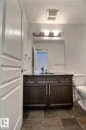 Dark wood-finish vanity with a dark countertop and integrated sink - 