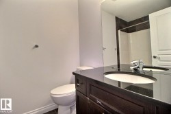 Dark wood-finish vanity with an undermount sink, dark stone-finish countertop, and polished chrome faucet - 
