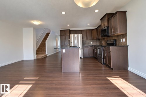 Spacious open-concept living area with wood-finish flooring - 5205 168 Avenue Nw, Edmonton, AB 