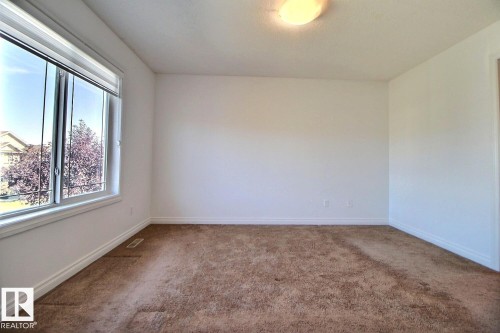 Large window with white trim, wall-to-wall carpeting, and overhead light fixture - 5205 168 Avenue Nw, Edmonton, AB 