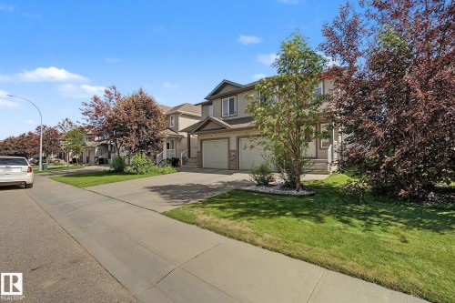 Two-story exterior with attached garage, stone accents, and concrete driveway - 5205 168 Avenue Nw, Edmonton, AB 
