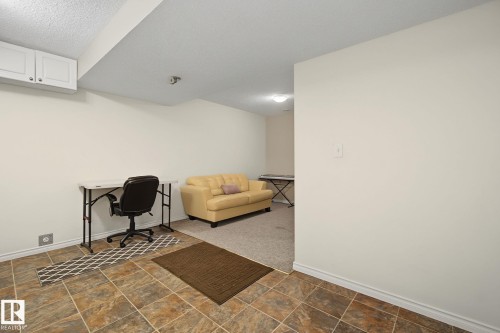 Tiled flooring with varying brown and terracotta hues, white shaker-style wall cabinetry, and neutral wall paint - 5205 168 Avenue Nw, Edmonton, AB 