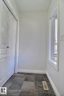 Tiled flooring throughout with a full-height window and baseboard trim - 