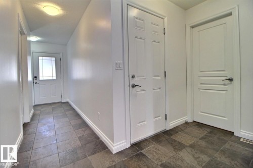Entryway featuring mixed-tone square tile flooring - 5205 168 Avenue Nw, Edmonton, AB 