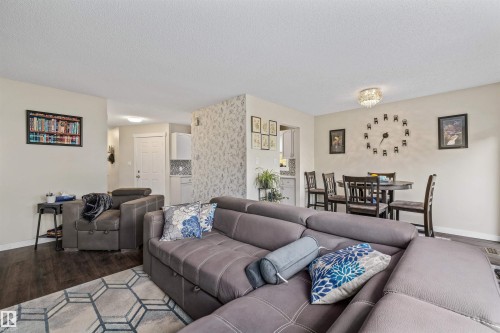 Open-concept living area with dark wood-finish flooring - #63 501 Youville Dr E Nw, Edmonton, AB 