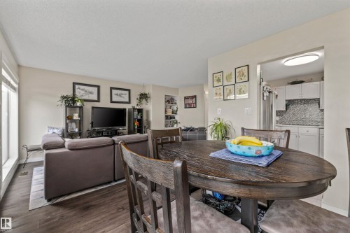 Open concept living and dining area with wood-finish flooring - #63 501 Youville Dr E Nw, Edmonton, AB 