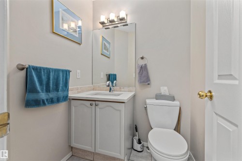 Built-in vanity with white cabinetry, integrated sink, and stone-look countertop - #63 501 Youville Dr E Nw, Edmonton, AB 