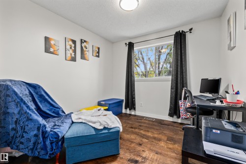 Recessed window with dark curtain rods, wood-finish flooring, and white painted walls - #63 501 Youville Dr E Nw, Edmonton, AB 