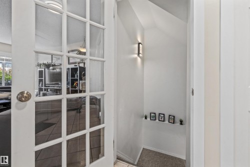 French doors with multiple panes, light wall colors, and a wall-mounted sconce - #63 501 Youville Dr E Nw, Edmonton, AB 