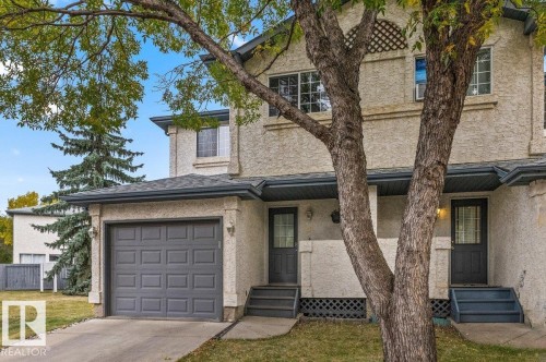 Stucco exterior with a peaked roof, attached single-car garage, and a concrete driveway - #63 501 Youville Dr E Nw, Edmonton, AB 