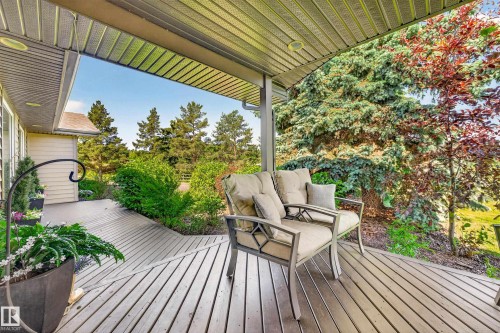 Covered porch featuring wood-finish decking and a slatted ceiling - 22245 Twp Road 512, Rural Strathcona County, AB 