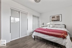 Room featuring wood-finish flooring, dual sliding-door closets with frosted glass panels, and a semi-flush mount drum light fixture - 