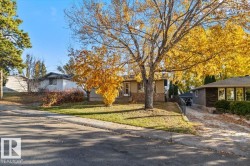 Single-story exterior featuring stone and siding facade, concrete driveway, and established trees - 