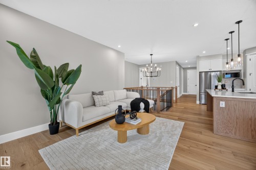 Open-concept living space featuring wood-finish flooring, recessed lighting, and a kitchen island with pendant lighting - 209 Hampshire, Sherwood Park, AB 