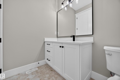 White vanity with a solid surface countertop, an undermount sink, and a matte black faucet - 209 Hampshire, Sherwood Park, AB 