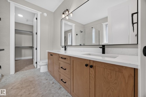 Dual vanity with white undermount sinks, quartz countertops, and matte black fixtures - 209 Hampshire, Sherwood Park, AB 
