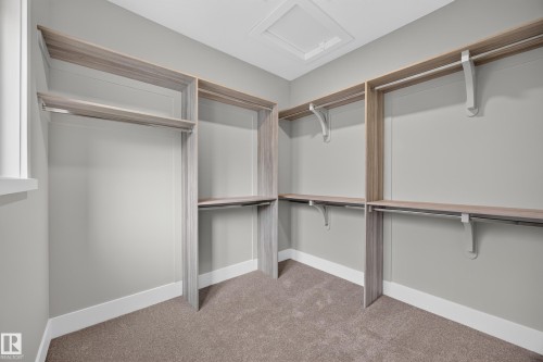Walk-in closet with carpet flooring, light gray walls, and wood-finish shelving - 209 Hampshire, Sherwood Park, AB 