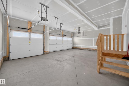Attached garage with two overhead doors, automatic openers, and concrete flooring - 209 Hampshire, Sherwood Park, AB 
