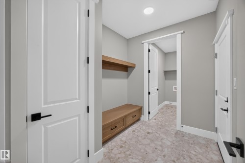 Built-in wood-finish bench with drawers, floating wood-finish shelving, and patterned tile flooring - 209 Hampshire, Sherwood Park, AB 