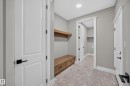 Built-in wood-finish bench with drawers, floating wood-finish shelving, and patterned tile flooring - 209 Hampshire, Sherwood Park, AB 