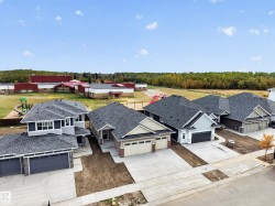 Newly constructed residential properties featuring concrete driveways and attached garages - 