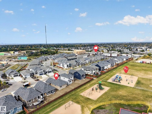 Aerial perspective showcasing nearby residential developments, a neighborhood park with playground equipment, and surrounding green spaces - 209 Hampshire, Sherwood Park, AB 