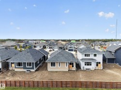 Newly constructed homes featuring various siding colors and roof styles, set within a developing residential community - 
