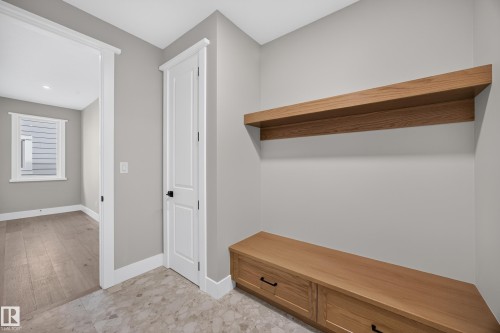 Built-in wooden bench with storage drawers, coordinating floating shelf, and neutral wall paint - 209 Hampshire, Sherwood Park, AB 