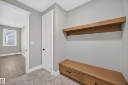 Built-in wooden bench with storage drawers, coordinating floating shelf, and neutral wall paint - 