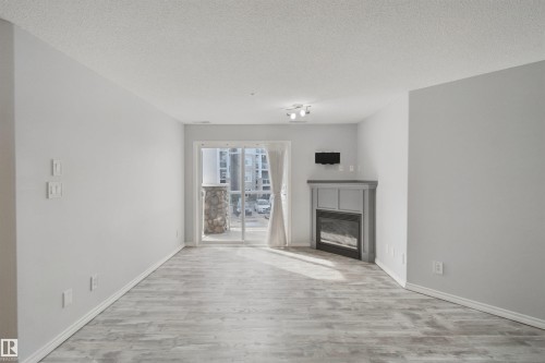 Light gray walls with wood-finish flooring - #208 16035 132 St Nw, Edmonton, AB 