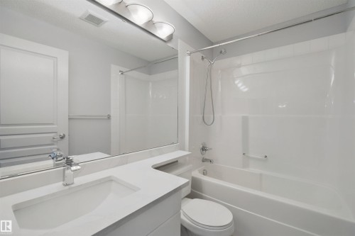 Vanity with integrated sink, chrome faucet, and expansive mirror - #208 16035 132 St Nw, Edmonton, AB 