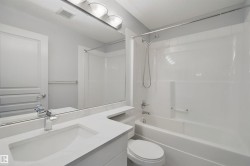 Vanity with integrated sink, chrome faucet, and expansive mirror - 