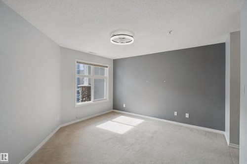 Recessed lighting, carpeted flooring, large window, and light-colored walls - #208 16035 132 St Nw, Edmonton, AB 