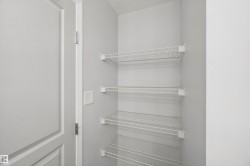 Built-in wire shelving within a storage closet, featuring light gray wall paint and white trim details - 