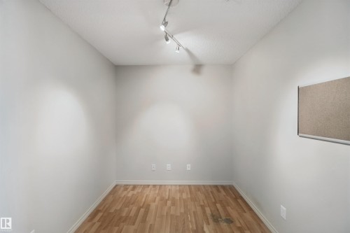 Wood-finish flooring, white walls, textured ceiling, track lighting fixture - #208 16035 132 St Nw, Edmonton, AB 
