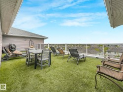 Rooftop terrace with artificial turf, glass panel railing, and exterior wall siding - 