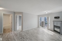 Wood-finish flooring throughout, sliding glass door leading to a balcony, modern fireplace, and recessed lighting - 