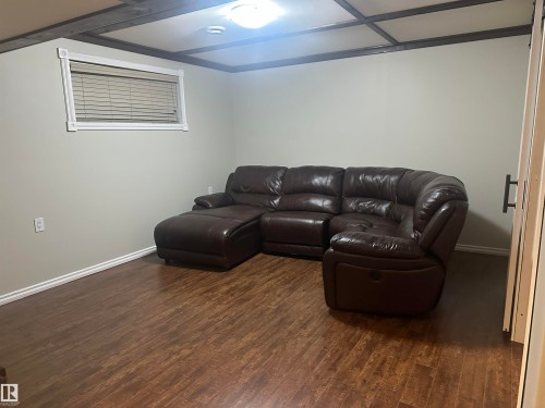 Wood-finish flooring with white baseboards, a window with white trim, and a ceiling light fixture - 35 Hudson Cove, Spruce Grove, AB 