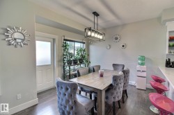 Dining area featuring wood-finish flooring, a rectangular light fixture, and a window with blinds - 