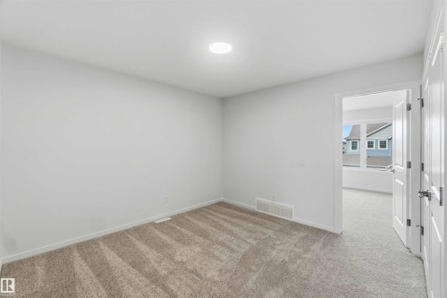Recessed ceiling lighting, neutral tone carpet, white interior door, and white trim - 5733 Hawthorn Common Sw, Edmonton, AB 