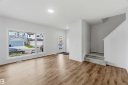 Open-concept living space featuring wood-finish flooring, recessed lighting, and a large picture window - 
