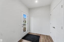 Entryway featuring wood-finish flooring, white walls, and a full-light entry door - 